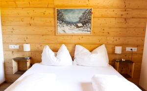 a bedroom with wooden walls and a bed with white pillows at Alpenchalet im Leutaschtal in Leutasch +37 photos