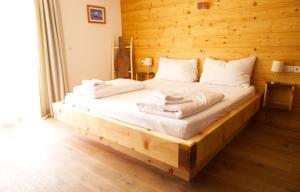 a bed in a room with a wooden wall at Alpenchalet im Leutaschtal in Leutasch