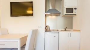 a small kitchen with a table and a microwave at Globales Janeiro in Can Picafort