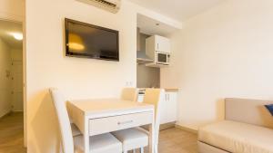a small apartment with a desk and a tv on the wall at Globales Janeiro in Can Picafort