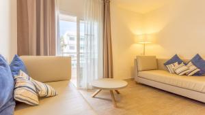 a living room with a couch and a chair at Globales Janeiro in Can Picafort