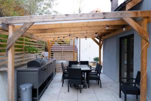 eine Terrasse mit Tisch und Stühlen unter einer Holzpergola in der Unterkunft Twin2 in Văliug