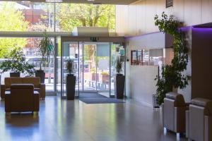 a lobby of a building with a door and plants at Hotel Creina in Kranj
