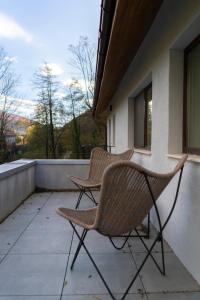 zwei Stühle stehen auf dem Balkon eines Hauses in der Unterkunft Twin2 in Văliug