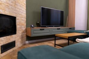 ein Wohnzimmer mit Fernseher und Kamin in der Unterkunft Twin2 in Văliug