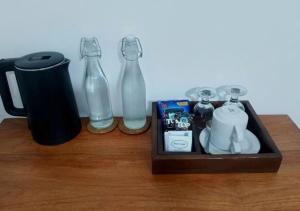 a wooden table with two glass bottles and a mug at Lonthar B&B - Adults Only in Riung