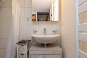 a bathroom with a white sink and a mirror at Charming Swiss Lake View studio apartment in Wädenswil