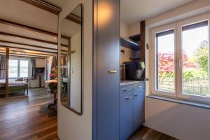 a room with a door and a kitchen with a window at Charming Swiss Lake View studio apartment in Wädenswil