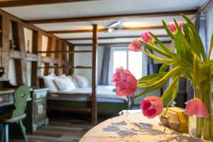 a room with a bed and a table with flowers at Charming Swiss Lake View studio apartment in Wädenswil