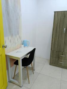 a small white table with a black chair next to a door at Scott's Seaview Resort in Idanao