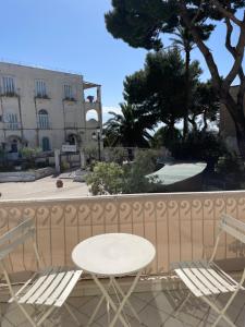 a white table and chairs on a balcony with a building at Cerio Guest House in Anacapri +8 photos