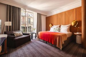 a hotel room with a bed and a chair at Hôtel Vernet Champs Elysées Paris in Paris