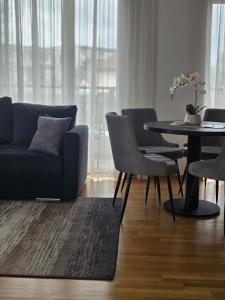 a living room with a blue couch and a table at Aura Apartmani Vrnjačka Banja in Vrnjci