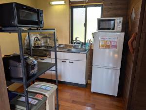 a kitchen with a microwave and a refrigerator at koco in Nishinoomote