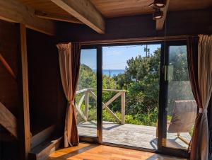 a room with a sliding glass door with a view of the ocean at koco in Nishinoomote