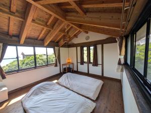 a bedroom with a bed in a room with windows at koco in Nishinoomote
