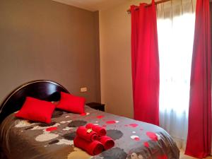 un dormitorio con una cama con animales de peluche rojos. en Apartamentos Tuara, en El Run