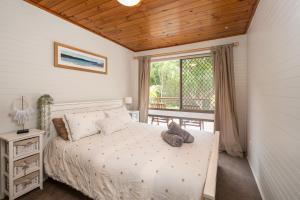 a bedroom with a white bed and a window at Drifters @ Callala Beach in Callala Beach +13 photos
