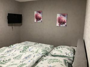a bedroom with a bed and three pictures on the wall at Ferienwohnung Wartehof in Bad Emstal