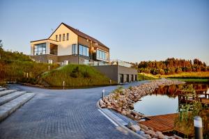 a house sitting on top of a hill next to a lake at Biała Woda in Suwałki