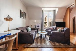 a living room with two chairs and a table at Hôtel Vernet Champs Elysées Paris in Paris