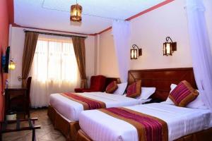 a hotel room with two beds and a window at Seasons Airport Hotel Nairobi in Nairobi +10 photos
