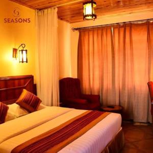 a hotel room with a bed and a chair at Seasons Airport Hotel Nairobi in Nairobi