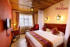 a bedroom with a bed and a chair in a room at Seasons Airport Hotel Nairobi in Nairobi