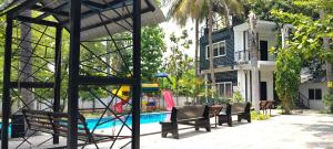 a group of benches next to a swimming pool at Moonlight Resorts Idappadi in Ammāpettai