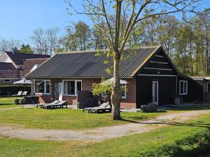a black house with benches in front of it at Little Creek - Lodges in het natuurgebied in Renesse