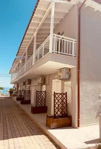 a white building with a staircase on the side of it at Salty Sea View Apartments in Polychrono