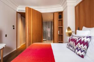 a bedroom with a bed with a red blanket at Hôtel Vernet Champs Elysées Paris in Paris +76 photos