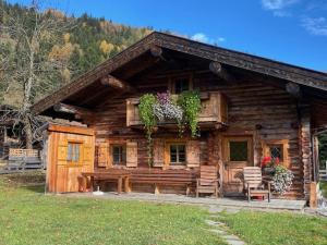 a log cabin with a bench and plants on it at Schröckhütte in Bad Hofgastein