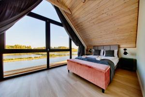 a bedroom with a bed and large windows at Biała Woda in Suwałki +93 photos