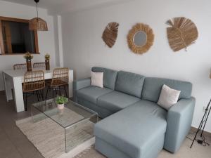 a living room with a blue couch and a table at Veneziola Golf II by Alina365 in La Manga del Mar Menor