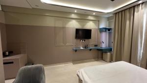 a room with a bed and a tv on the wall at Us Group Stays Omaxe Hazratganj in Nalmatha