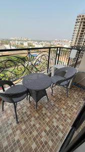 a balcony with two tables and chairs on a balcony at Us Group Stays Omaxe Hazratganj in Nalmatha