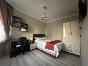 a bedroom with a bed and a desk and a chair at Borahan Hotel in Trabzon