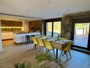 a dining room with a table and yellow chairs at Mar Do Val in Muxia