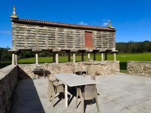 a table and chairs in front of a stone building at Mar Do Val in Muxia