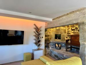 a living room with a stone wall with a fireplace at Mar Do Val in Muxia