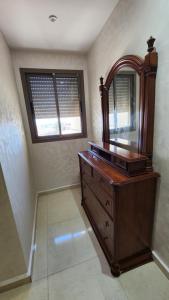 a bathroom with a wooden dresser and a mirror at Sidi Rahal in Sidi Rahal +1 photo