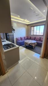 a kitchen and living room with a couch and a table at Sidi Rahal in Sidi Rahal