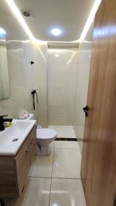 a bathroom with a toilet and a sink and a shower at Sidi Rahal in Sidi Rahal