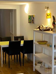 a dining room with a white table and black chairs at Zentrales Schloss Apartment in Arbon