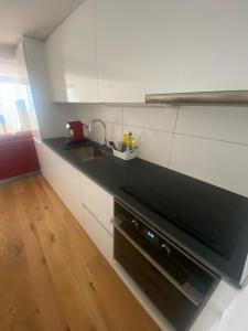 a kitchen with a black counter and a sink at Zentrales Schloss Apartment in Arbon +6 photos