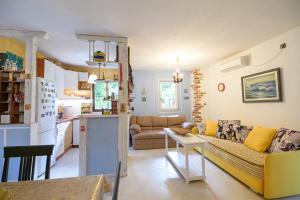 a living room with a yellow couch and a kitchen at Nostromo in Kotor +17 photos
