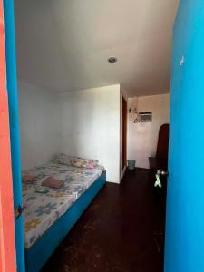 a small bedroom with a bed in a room at Scott's Seaview Resort in Idanao