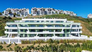 an apartment building on a hill with houses at Oasys de Ipanema in La Cala de Mijas