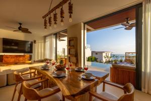 a dining room with a table and a view of the ocean at Villa Gaia in Ko Phangan
